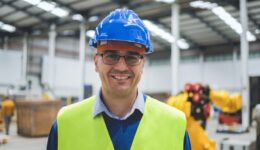 Happy engineer working inside robotic facility - New industrial tech concept